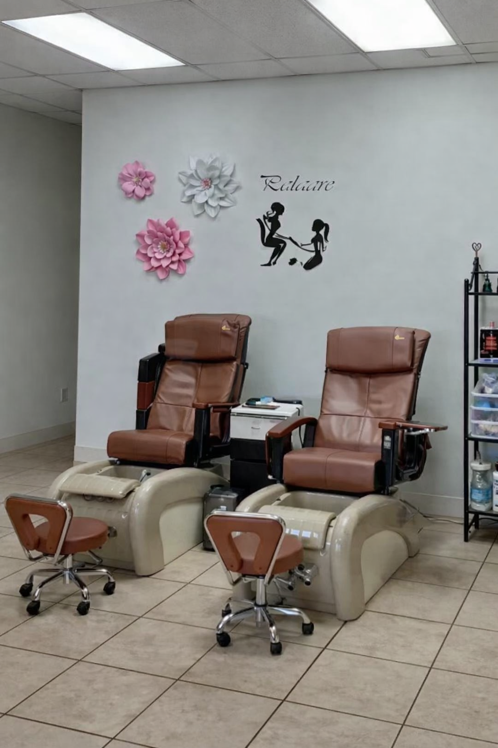 Pedicure chairs and floral wall details inside the salon